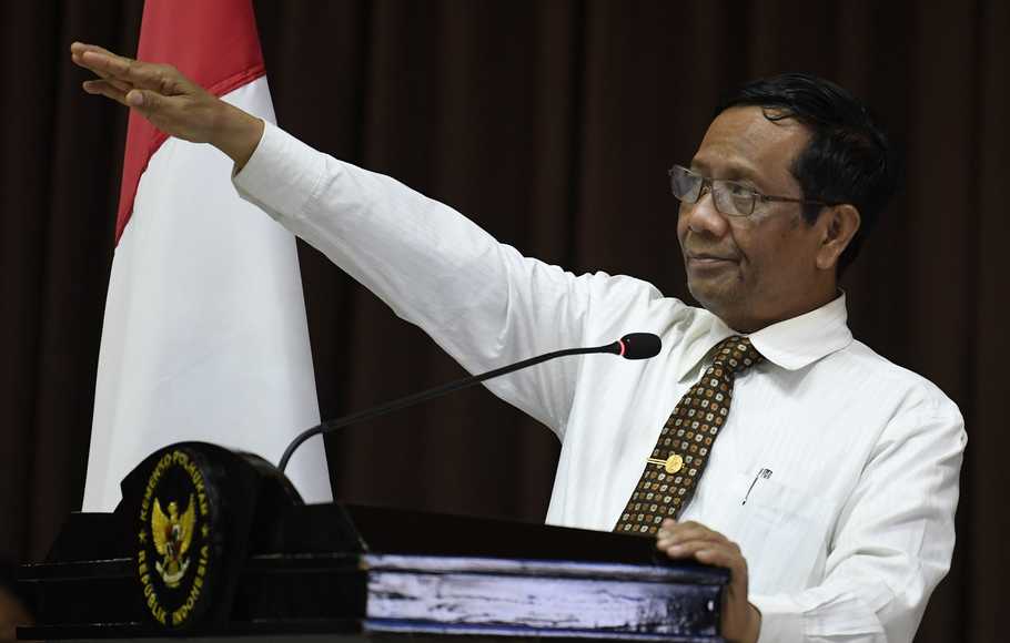 Menteri Koordinator Politik, Hukum dan Keamanan Mahfud MD (kiri) menyerahkan kompensasi secara simbolis kepada keluarga korban tindak pidana terorisme di Kemenkopolhukam, Jakarta,