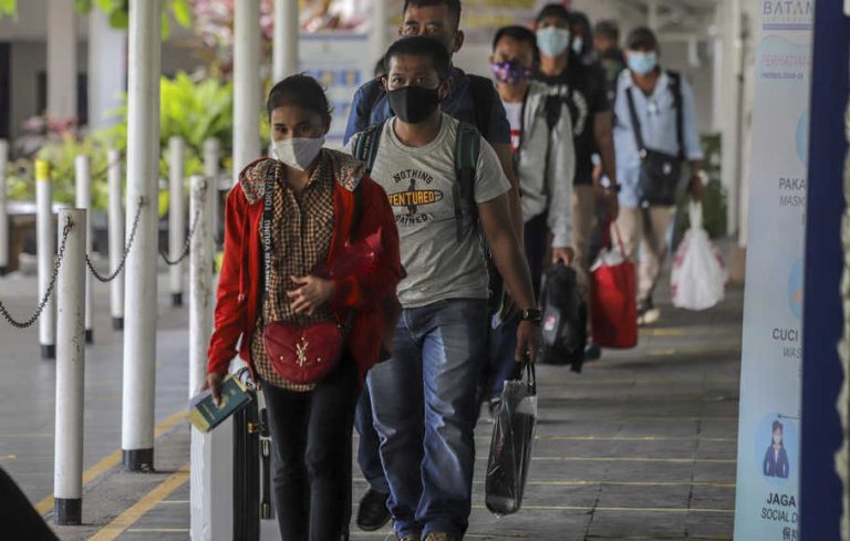 Sejumlah Pekerja Migran Indonesia (PMI) berjalan menuju tempat pengecekan dokumen perjalanan di Pelabuhan Internasional Batam Centre, Batam, Kepulauan Riau, Kamis (29/4/2021).