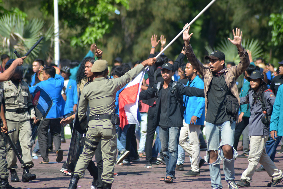 Aparat gabungan Polisi dan Satpol PP menggunakan tongkat menghalau demonstran saat terjadi kerusuhan dalam aksi menolak perusahaan tambang PT Emas Mineral Murni ( PT EMM) di kantor gubernur Aceh, banda Aceh, Selasa (9/4/2019).